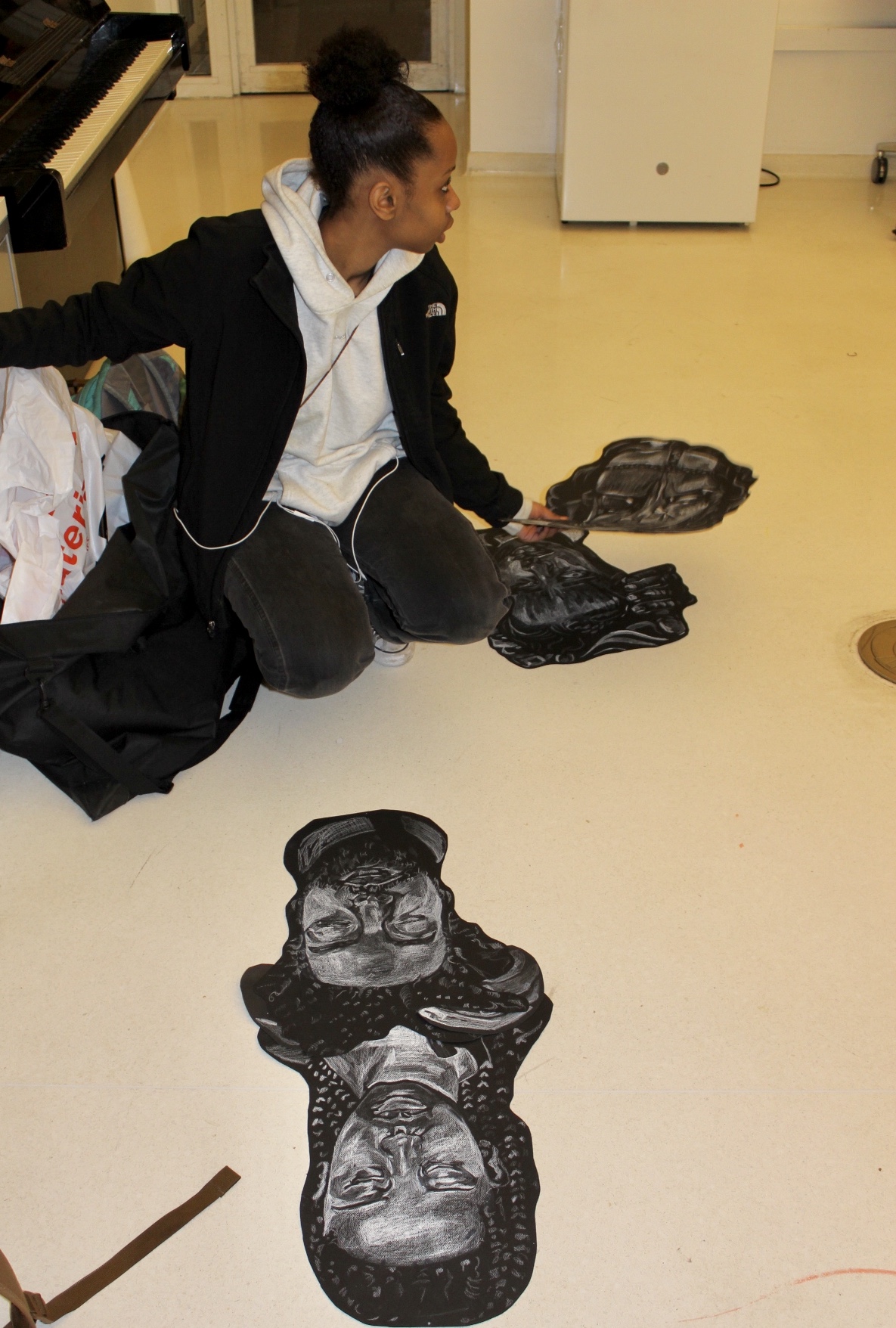 Mahlet sitting on the floor with her work laying infront of her