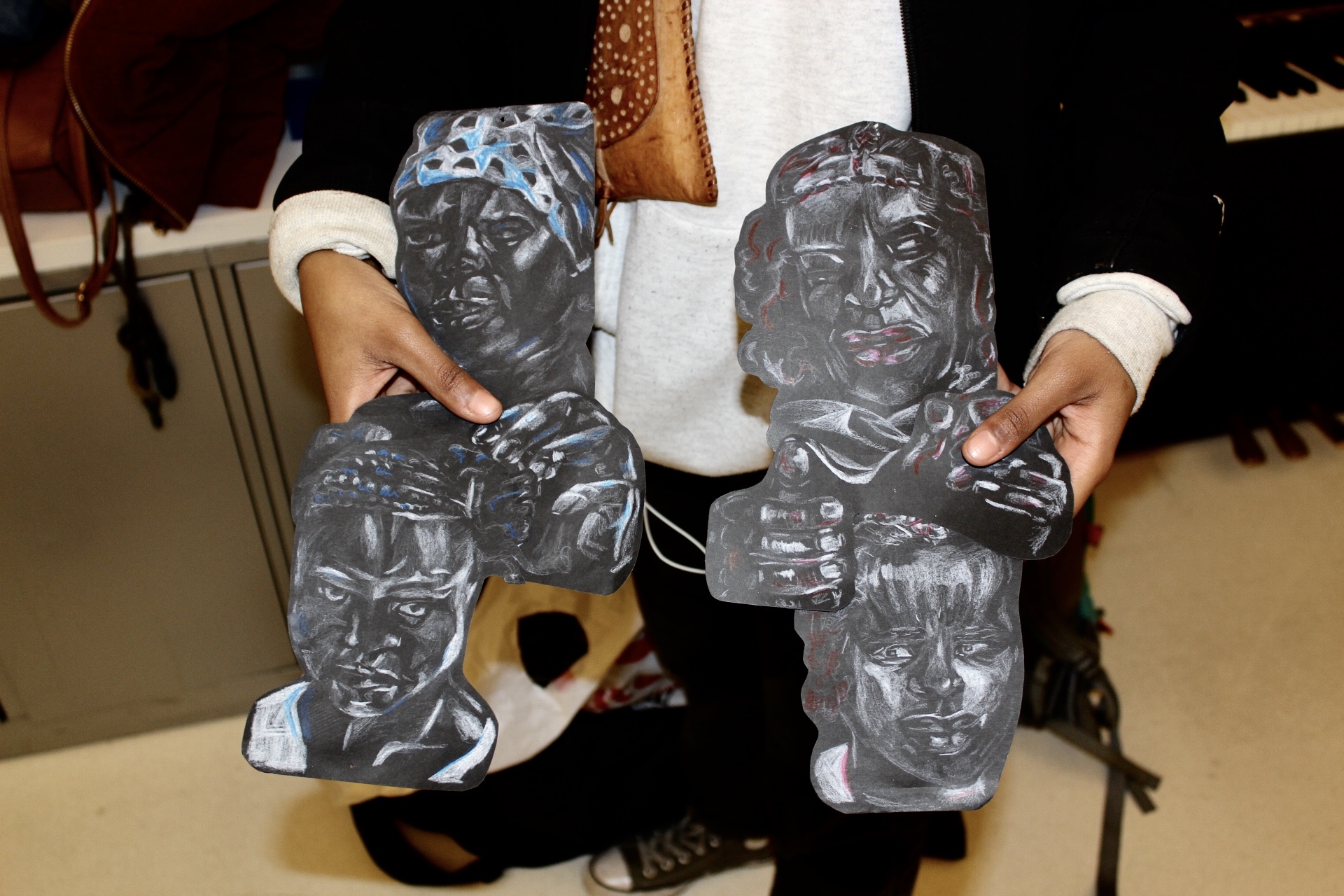 Mahlet holding her charcoal drawing up for a close up shot