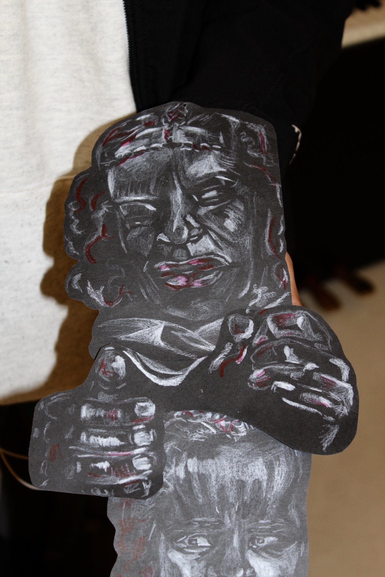 Mahlet holding her charcoal drawing up for a close up shot