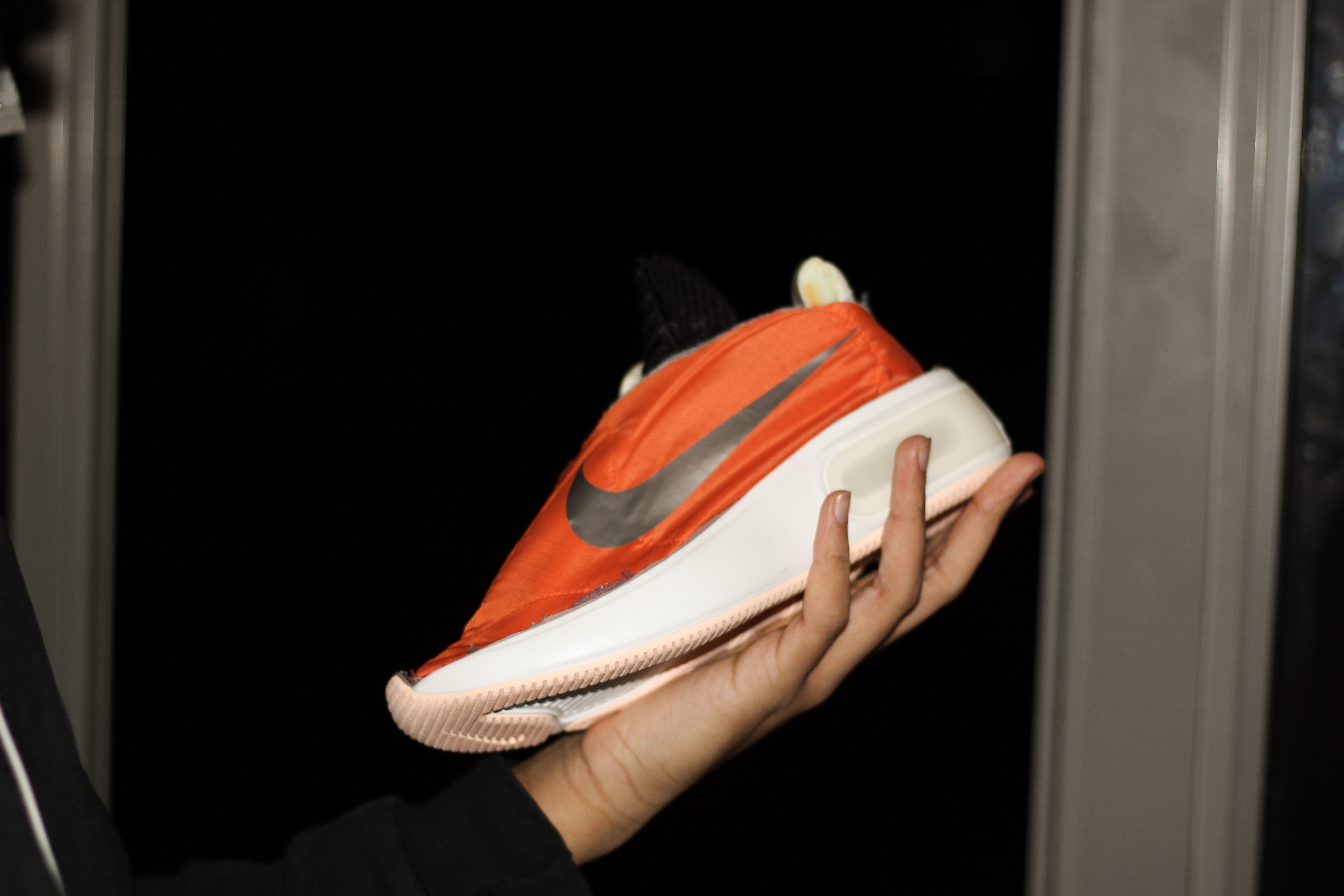 orange sneaker being held