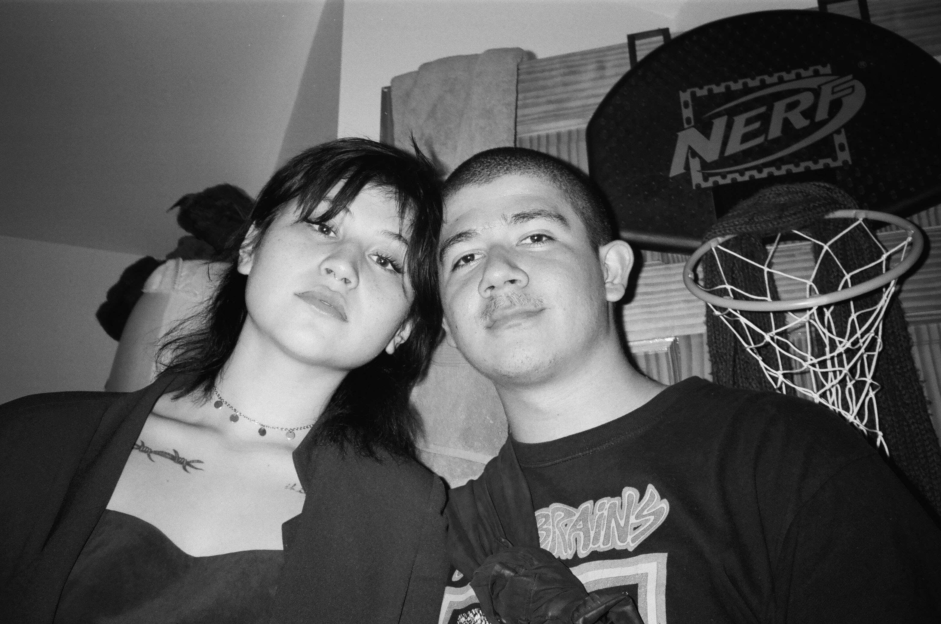 two people looking directly at the camera witht their heads touching